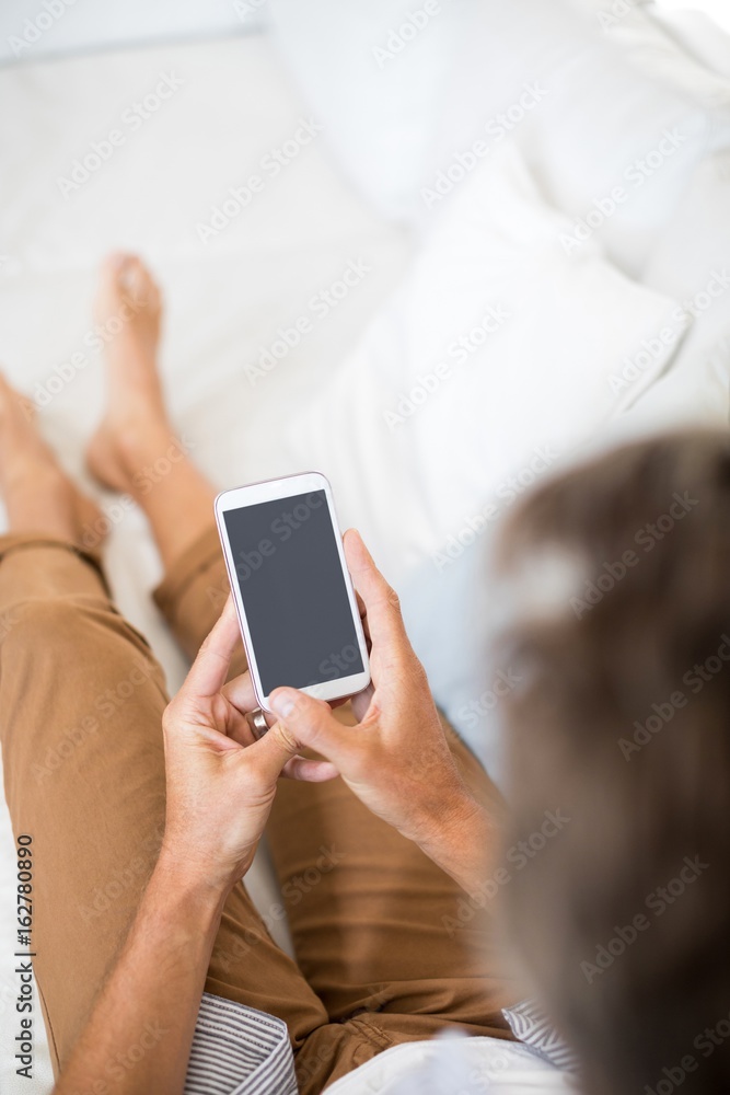 Man using mobile phone in living room Man using mobile phone in living room