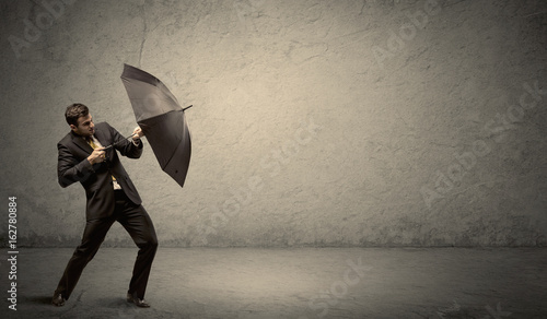 Handsome business man holding umbrella with copy space background