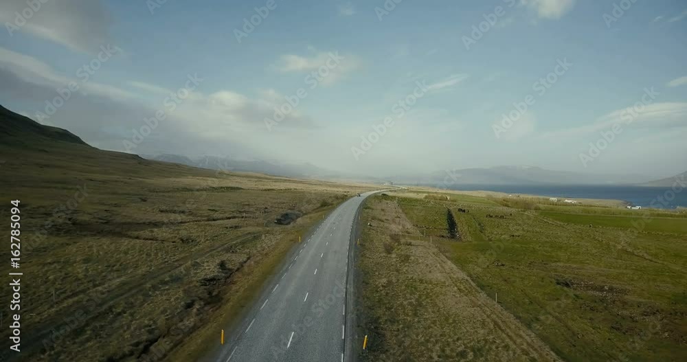 Copter flying over the traffic road with cars riding on it. Beautiful scenic view of the fields and shore of the ocean. Copter flying over the traffic road with cars riding on it. Beautiful scenic view of the fields and shore of the ocean.