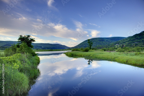 A view from Cape Breton with clear blue waters and green marshes.