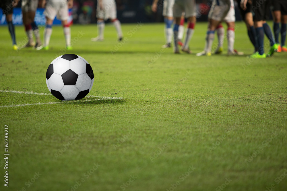 The soccer ball rests on the lawn while waiting for the footballer's ready.