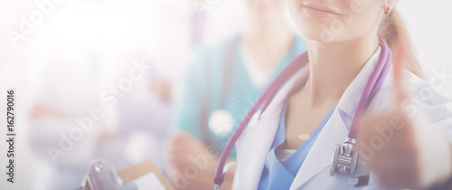 Attractive female doctor in front of medical group photo