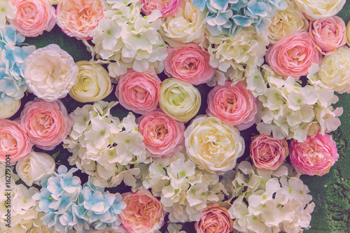 Beautiful multicolored artificial flowers background. flowers decor.