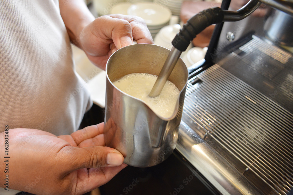 Barista is making a milk froth.