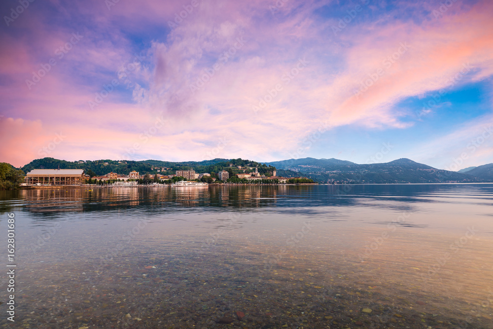 Fototapeta premium Lake Maggiore, colorful sky, northern Italy. Enchanting view of the city of Arona, province of Novara, Piedmont side of Lake Maggiore