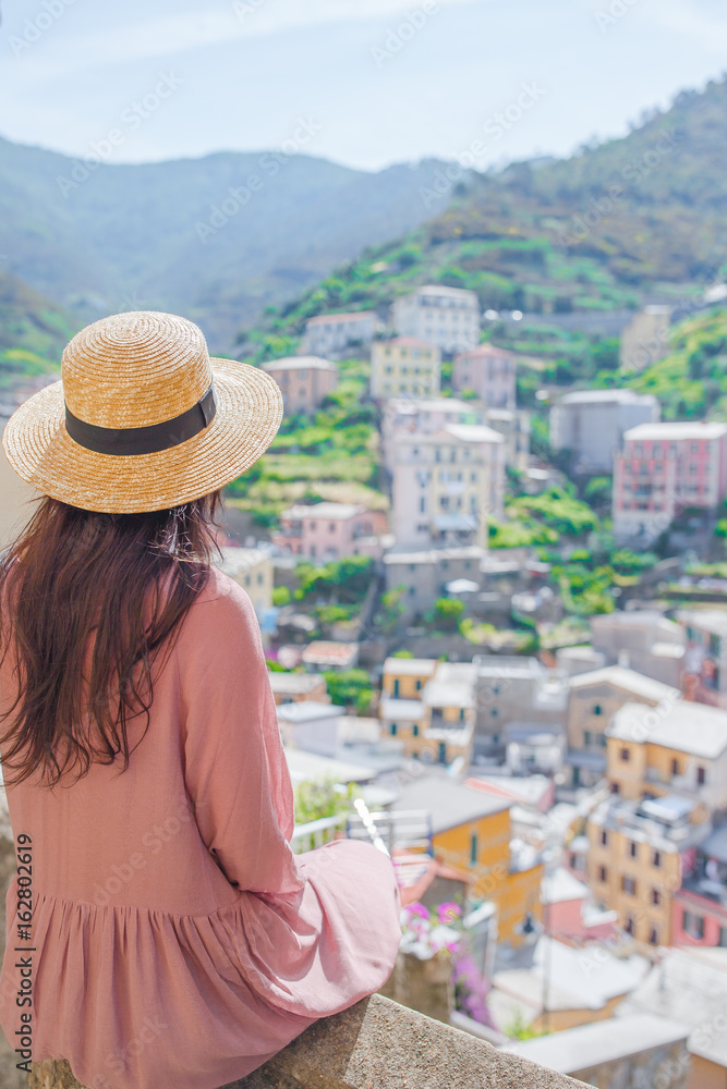 Beautiful woman with amazing view of the italian village in old street in Cinque Terre, Italy