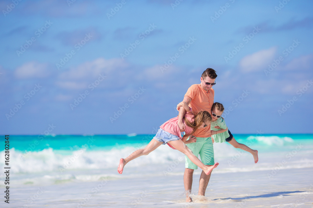 Family on white tropical beach have a lot of fun
