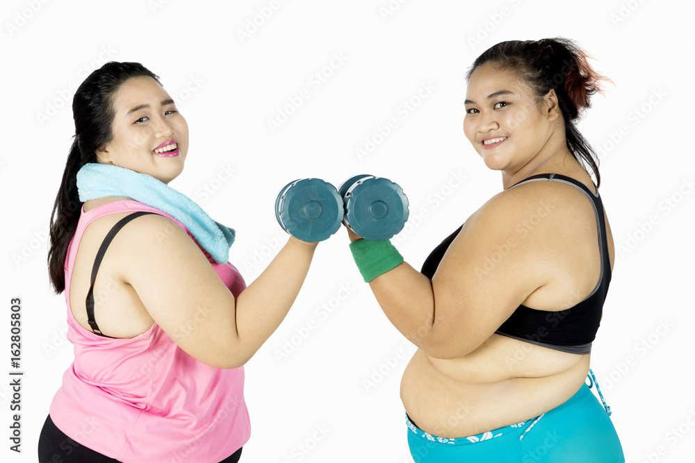 Fat women train with dumbbells on studio Fat women train with dumbbells on studio