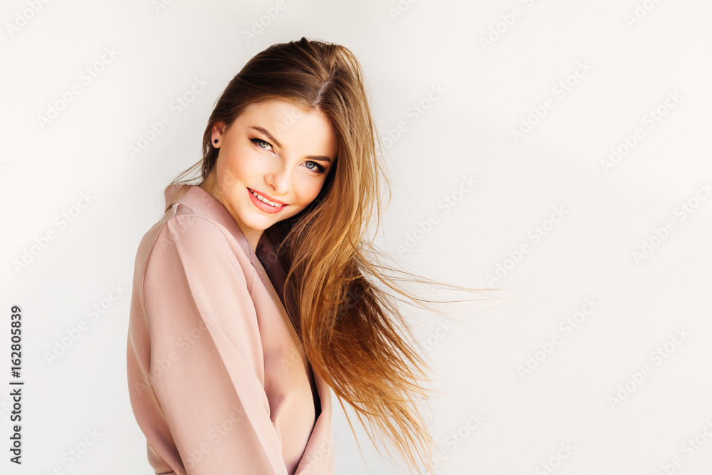 Blond beautiful girl throwing her hair in motion and looking into the camera on white background Blond beautiful girl throwing her hair in motion and looking into the camera on white background