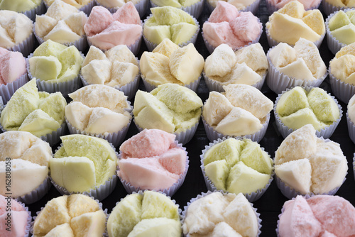 colorfull Thai dessert Thai steamed cupcakes or cakes cotton wool in paper cup on wood table photo