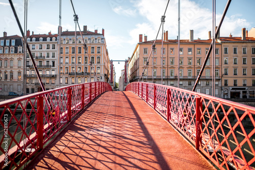 Morning view on the red footbridge and the riverside with beautiful buildings in Lyon city