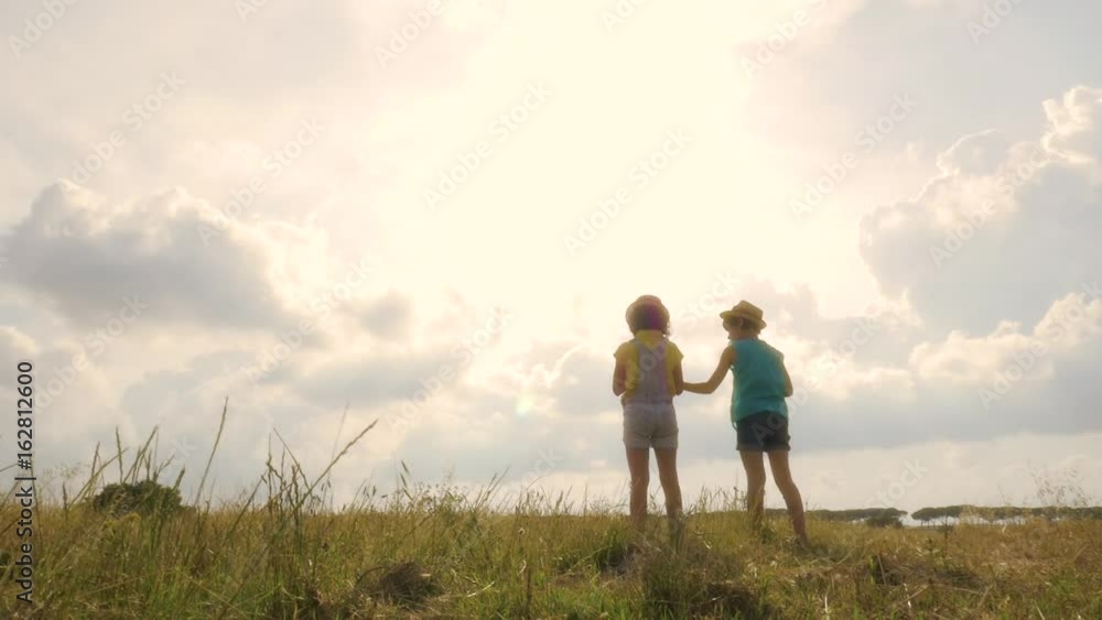 Young Girls Walking in Wheat Field Picking Flowers Young Girls Walking in Wheat Field Picking Flowers