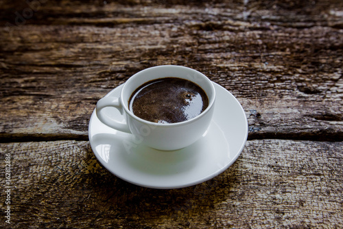 A cup of coffee on a wooden background photo