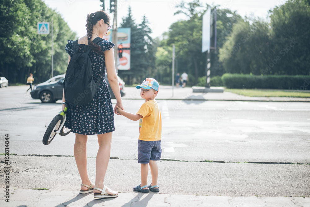 mother with son stands on traffic light