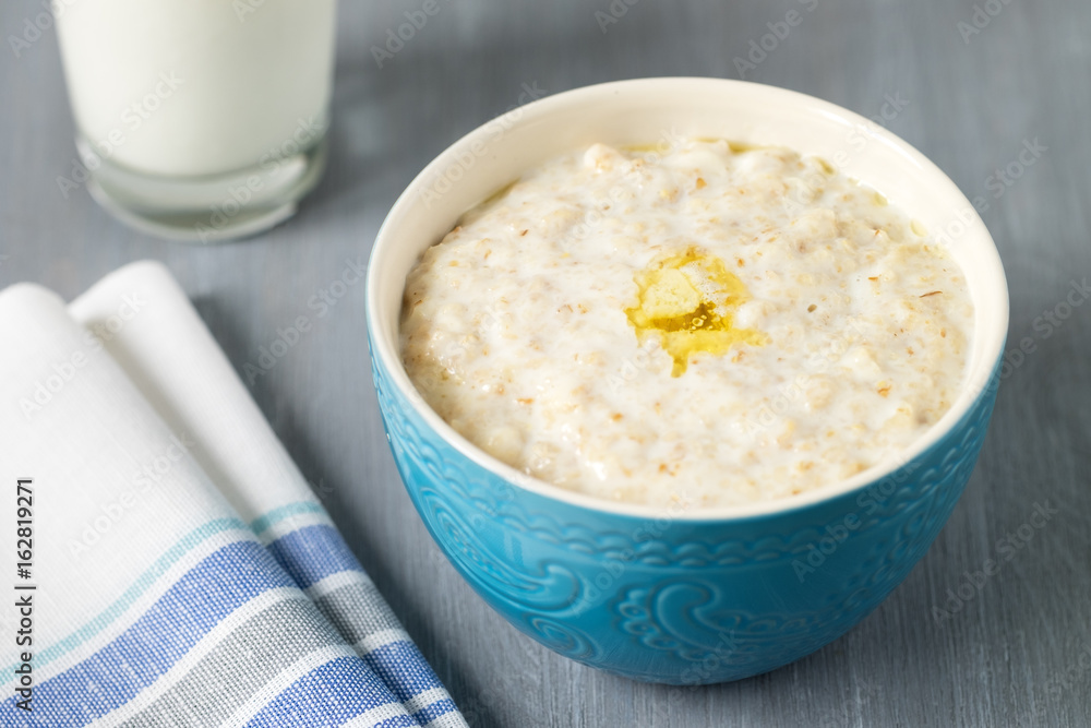 Oatmeal with a Pat of butter in a blue bowl on the table Oatmeal with a Pat of butter in a blue bowl on the table
