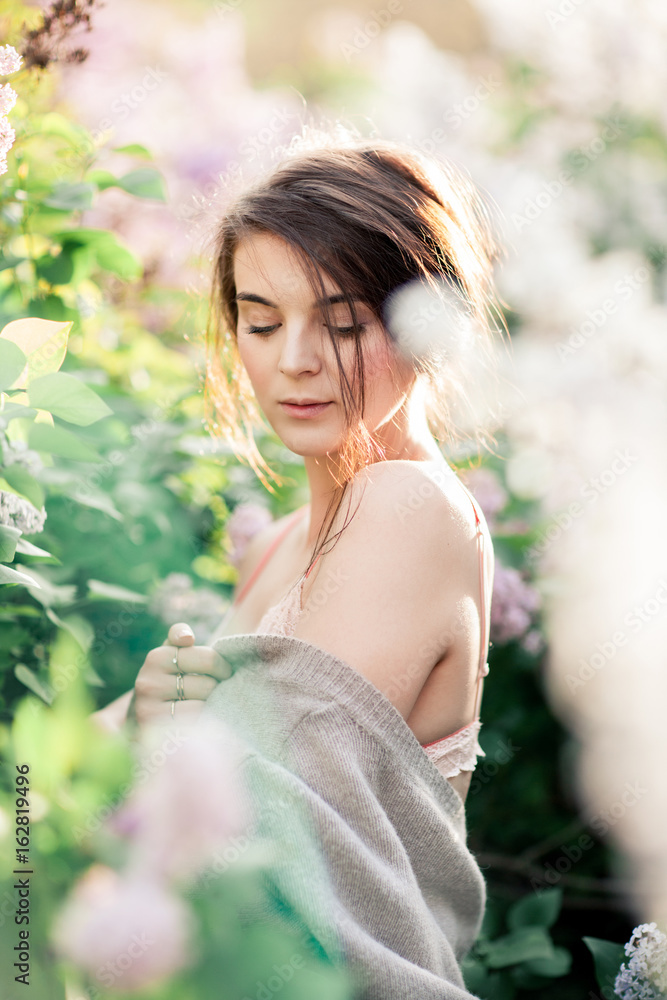 Young Girl in Lace bra Posing in Blossomed Lilac. Sunset tunes. Tender Mood Young Girl in Lace bra Posing in Blossomed Lilac. Sunset tunes. Tender Mood