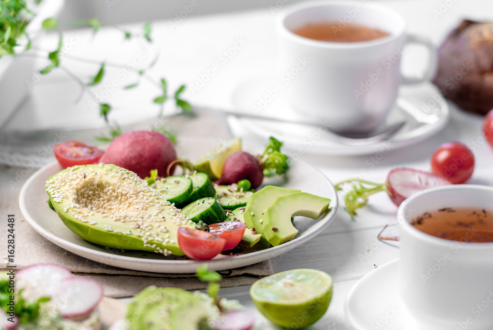 Flatbread with avocado and raddish, cup of tea Flatbread with avocado and raddish, cup of tea