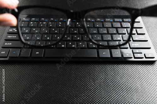 eyeglasses and keyboard on the table