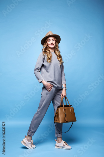 Beautiful woman sexy glamour fashion style wear clothes casual suit shirt and pants trendy accessory bag hat catalog spring collection casual businesswoman party date meeting makeup comfort sport.