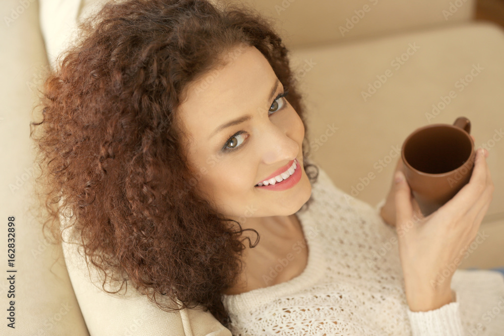 custom made wallpaper toronto digitalYoung beautiful woman holding cup of coffee and sitting on sofa in the room