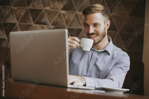 Man sitting in cafe, drinki...