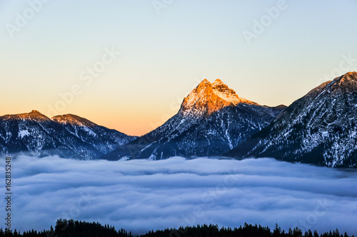 Beautiful evening view of Guffert mountain and Unnuetz mountain on the right shortly before sunset on a late autumn day with fog in the lowland. Located in the Rofan mountain range in Tyrol, Austria. photo