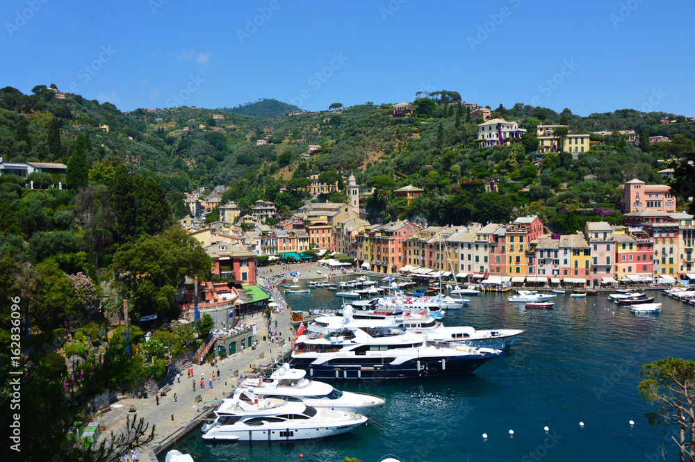 PORTOFINO, ITALY - JUNE 13, 2017: The beautiful Portofino with colorful houses and villas, luxury yachts and boats in little bay harbor. Liguria, Italy, Europe 