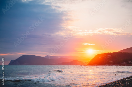 Warm sunset or sunrise on ocean and mountains. Beautiful colors