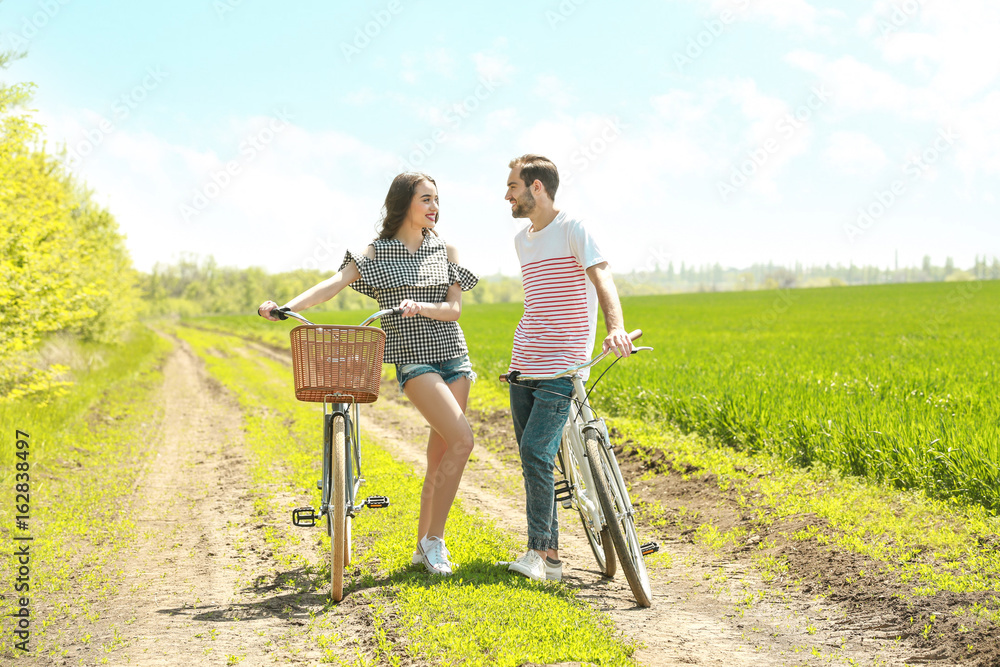 Happy young couple with bicycles in countryside Happy young couple with bicycles in countryside