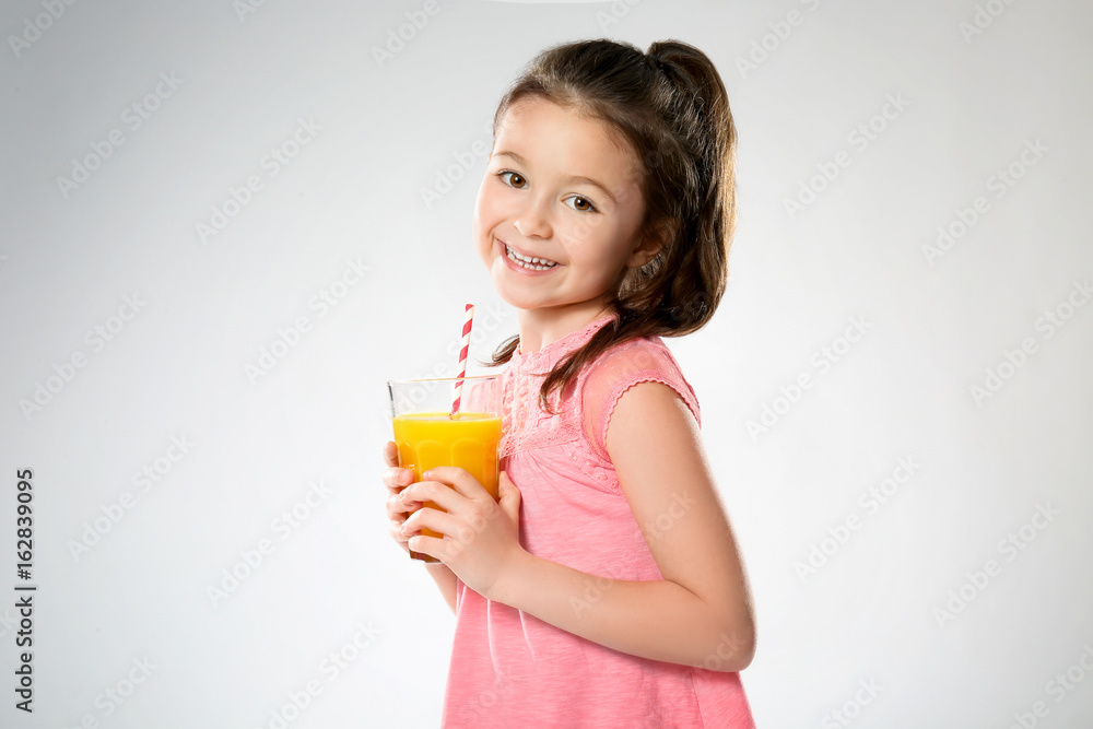Cute little girl with glass of juice on light background Cute little girl with glass of juice on light background