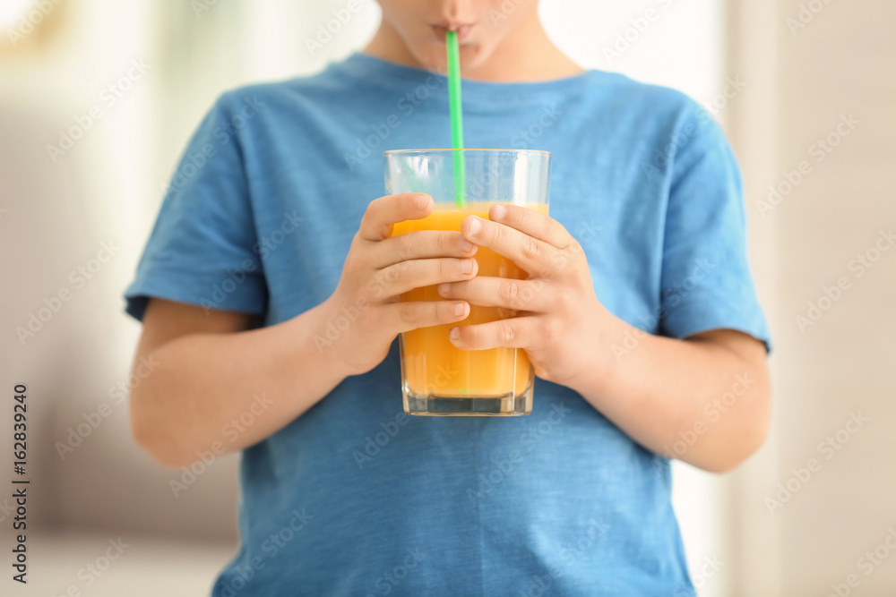 Cute little boy drinking juice at home, closeup Cute little boy drinking juice at home, closeup