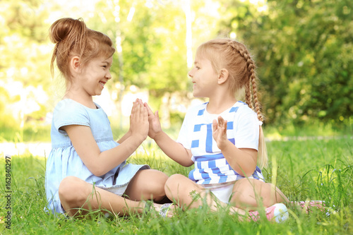 Cute little girls sitting o...