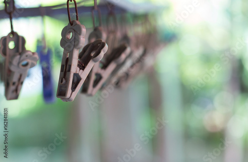 Clothes pegs or clothespins hang on a cord or a washing line.(selective focus)