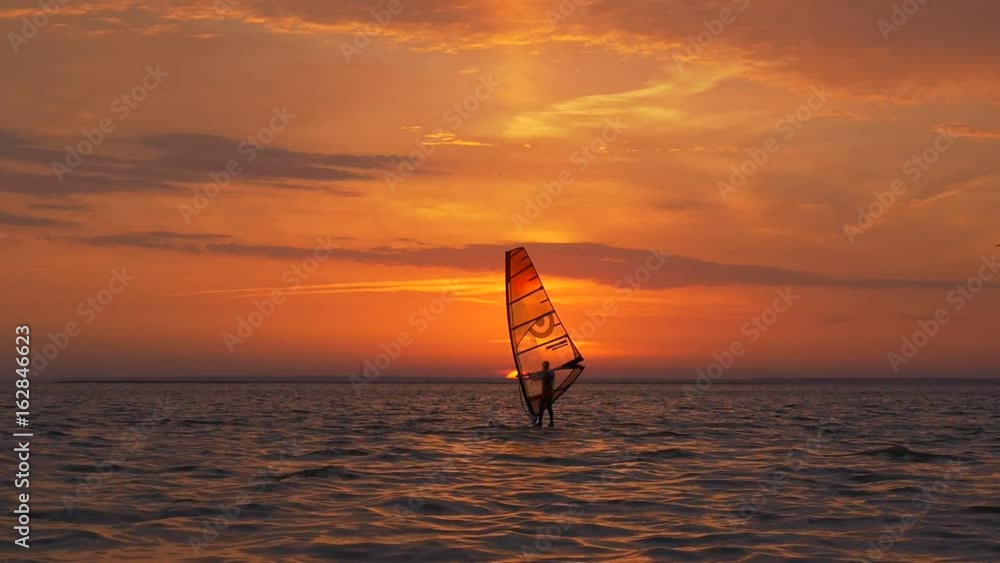 Windsurfing at breathtaking view of sunset Windsurfing at breathtaking view of sunset