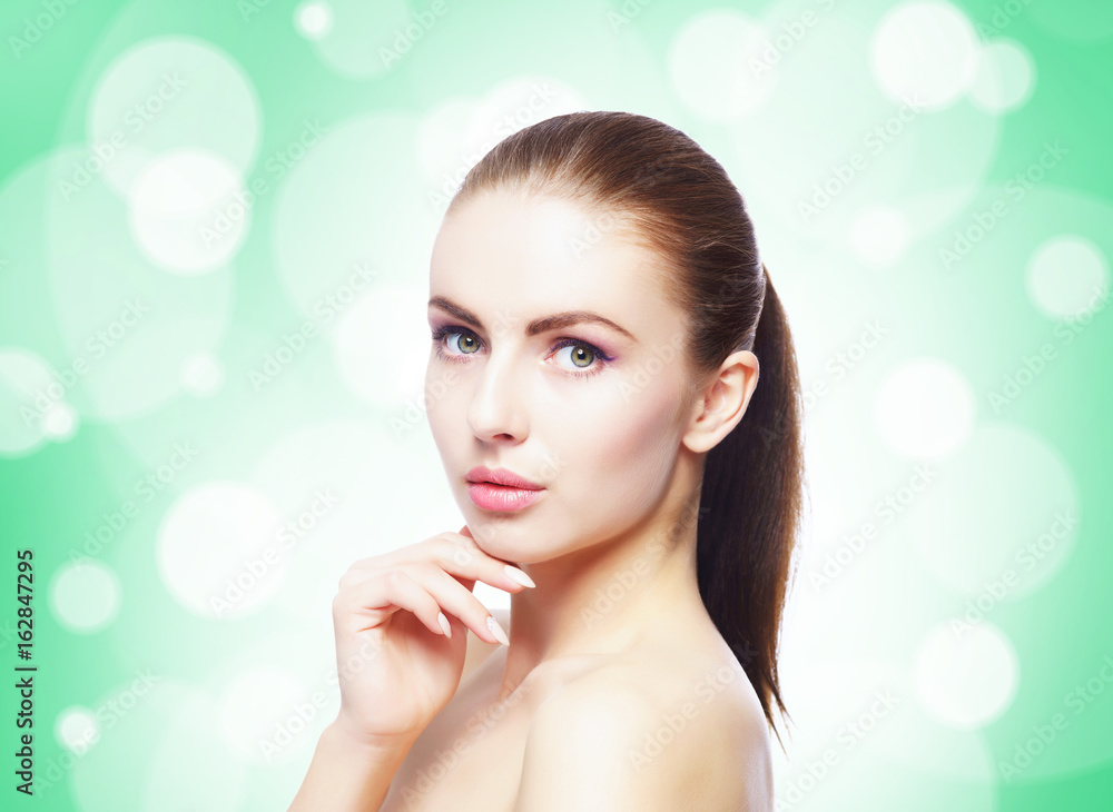 Portrait of young, beautiful and healthy woman: over teal background. Healthcare, spa, makeup and face lifting concept. Portrait of young, beautiful and healthy woman: over teal background. Healthcare, spa, makeup and face lifting concept.