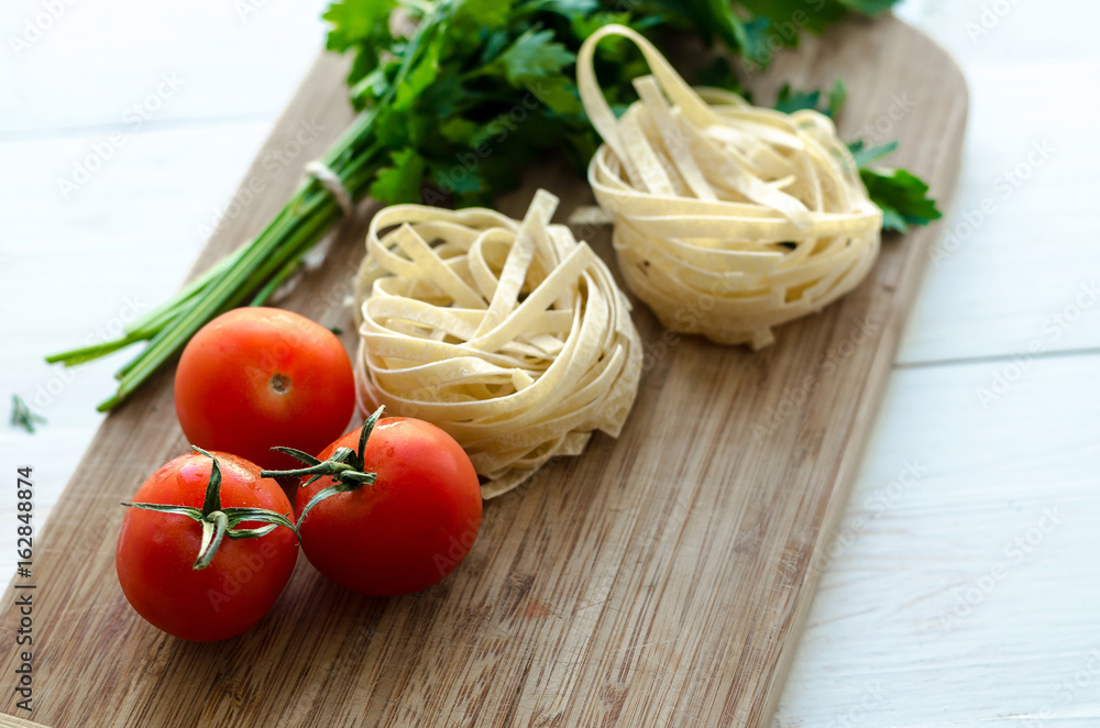 Ingredients for cooking Italian pasta - spaghetti, tomatoes, basil and garlic.