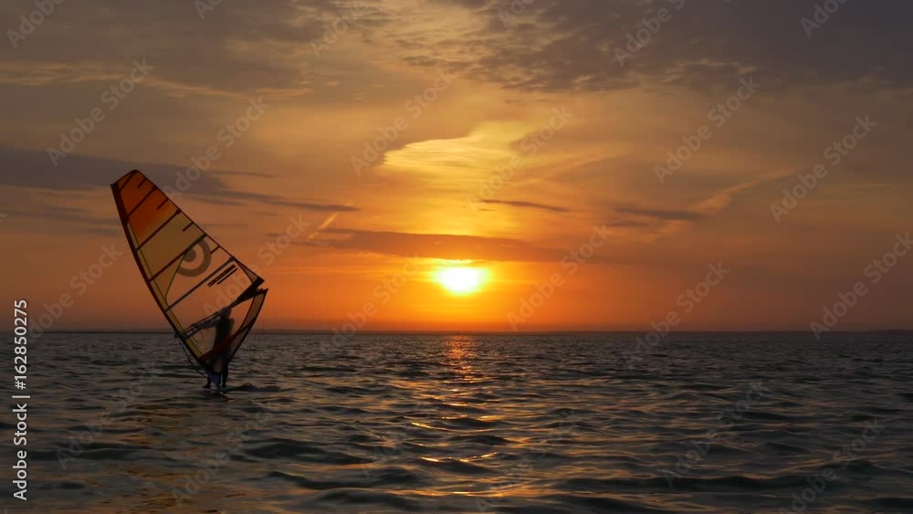 Aquatics, windsurfing in sea at sunset Aquatics, windsurfing in sea at sunset
