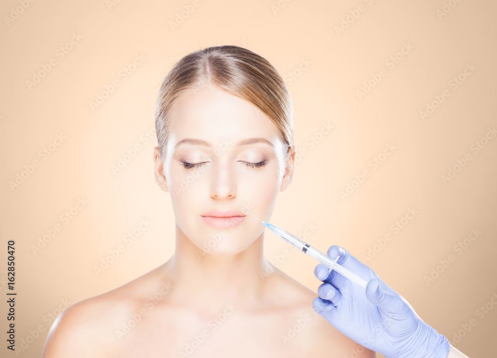 Doctor injecting in a beautiful face of a young woman. Plastic surgery concept. Doctor injecting in a beautiful face of a young woman. Plastic surgery concept.