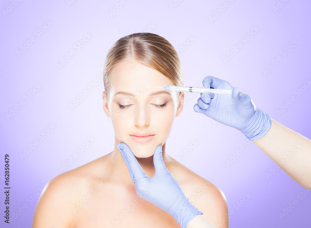 Doctor injecting in a beautiful face of a young woman. Plastic surgery concept. Doctor injecting in a beautiful face of a young woman. Plastic surgery concept.