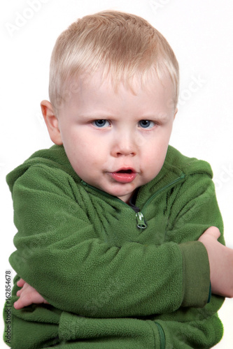 Slika na platnu Little child with chubby cheeks looking defiant and upset.
