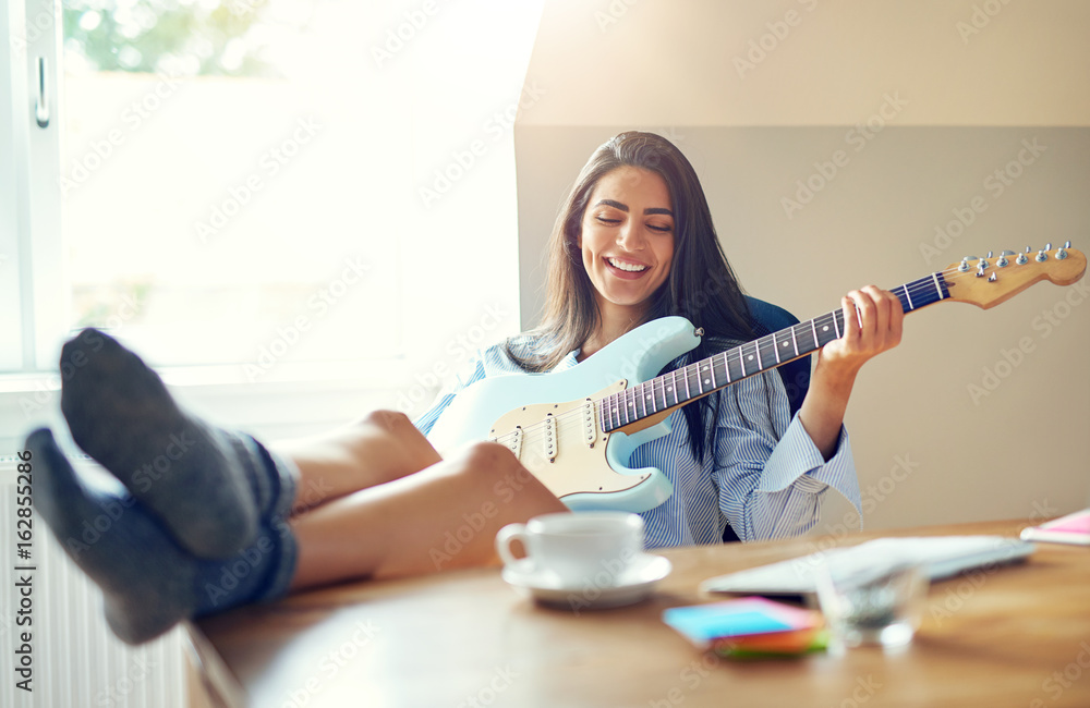 Beautiful girl singing while playing her guitar Beautiful girl singing while playing her guitar