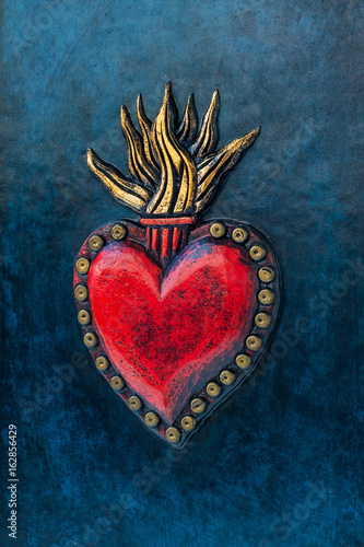 Red sacred heart on blue background