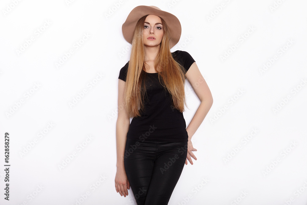 Young beautiful fashion model in women black t-shirt trendy hat posing in studio against white background Young beautiful fashion model in women black t-shirt trendy hat posing in studio against white background
