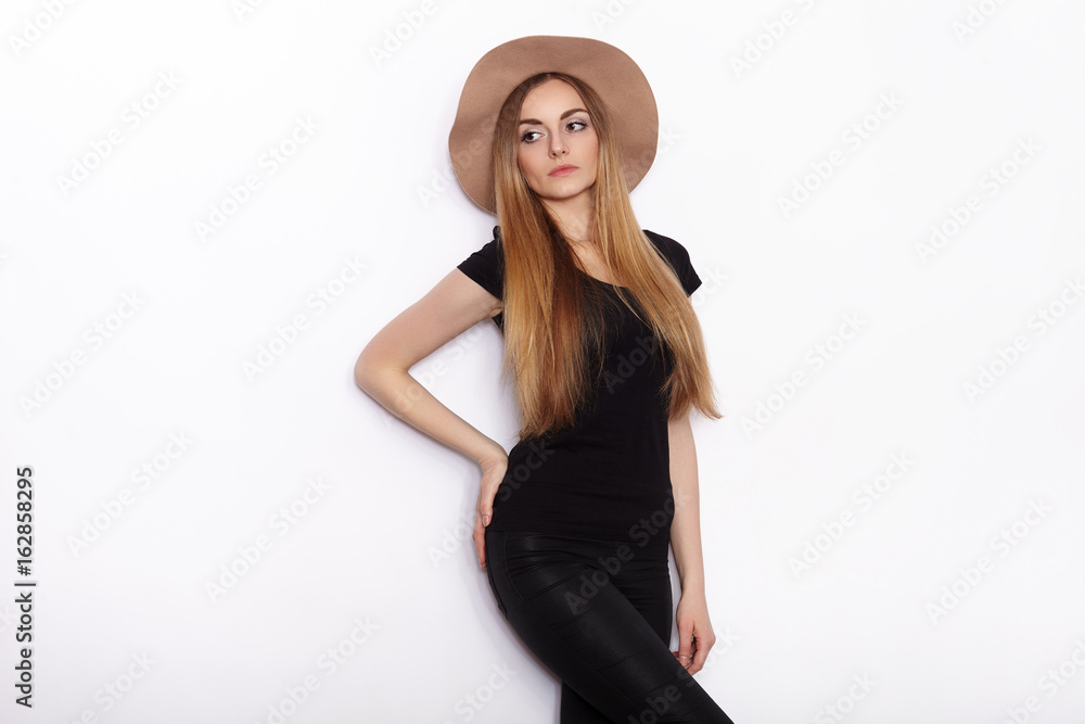 Young beautiful fashion model in women black t-shirt trendy hat posing in studio against white background Young beautiful fashion model in women black t-shirt trendy hat posing in studio against white background