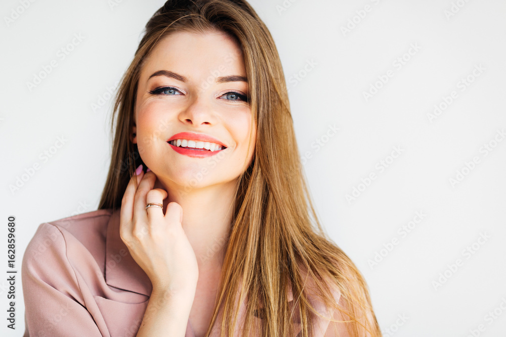Blond young woman smiling at the camera on white background Blond young woman smiling at the camera on white background