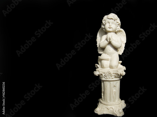 Statuette of an angel on black background