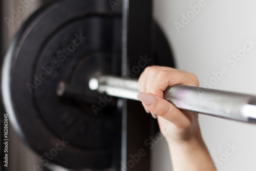 woman's hand on a barbell 