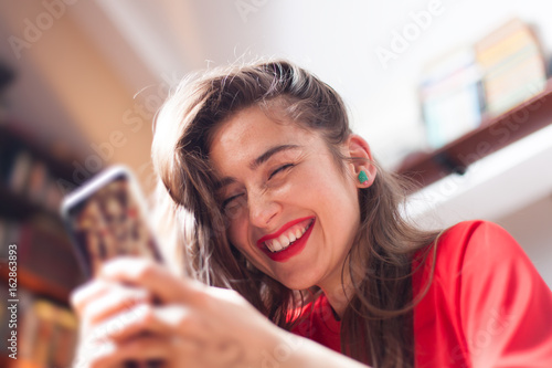 Fotografie young woman texting on smartphone