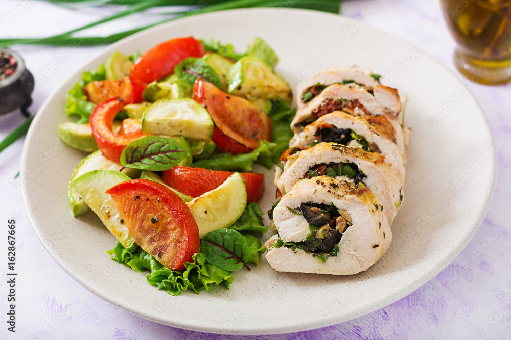 Baked chicken rolls with greens and olives, and baked vegetables - zucchini and tomatoes.
