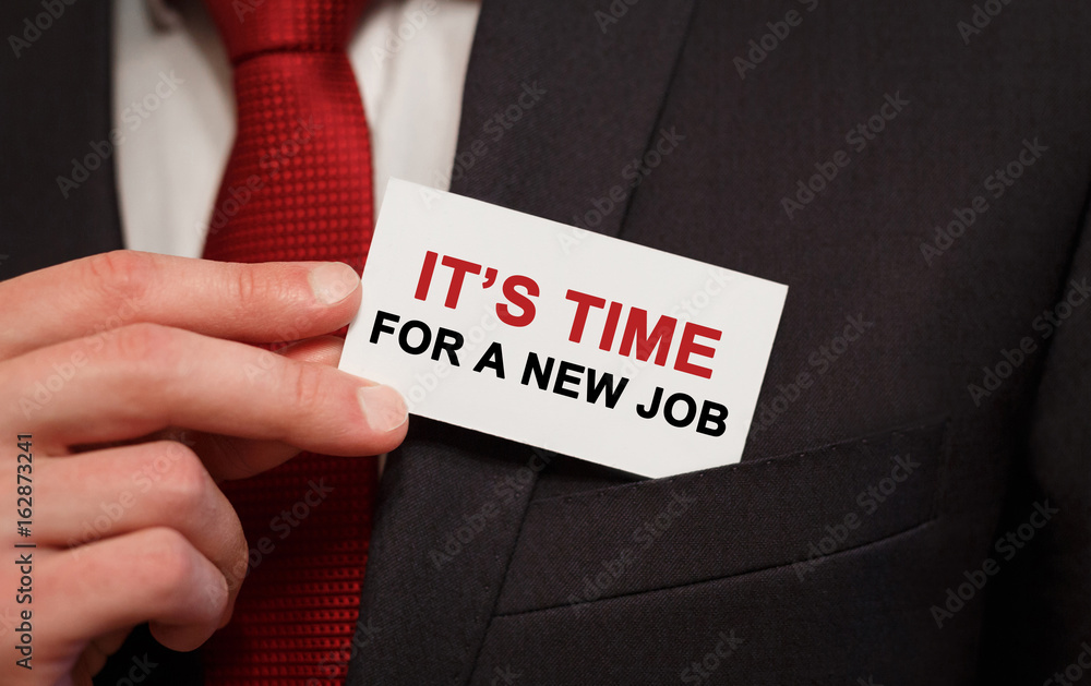 Businessman putting a card with text IT'S TIME FOR A NEW JOB in the pocket Businessman putting a card with text IT'S TIME FOR A NEW JOB in the pocket